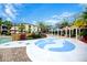 Community pool area with splash pad, colorful gazebos, and plenty of lounge chairs at 8819 Dunes Ct # 208, Kissimmee, FL 34747