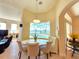 Bright breakfast nook features a round table, upholstered bench seating, and views of the screened-in pool and lake at 9137 Southern Breeze Dr, Orlando, FL 32836