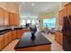 Beautiful kitchen with island, black countertops, wood cabinets and dining area at 9137 Southern Breeze Dr, Orlando, FL 32836