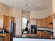 Open kitchen with black countertops and wood cabinets overlooking dining space at 9137 Southern Breeze Dr, Orlando, FL 32836