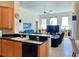 Open-concept living room with tile floors, ceiling fan, and kitchen breakfast bar at 9137 Southern Breeze Dr, Orlando, FL 32836