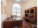 Office area featuring hardwood floors, a large window, and built-in shelving at 9137 Southern Breeze Dr, Orlando, FL 32836