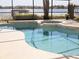 Inviting swimming pool and spa with serene lake backdrop and screened enclosure at 9137 Southern Breeze Dr, Orlando, FL 32836
