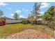 Grassy backyard features brick patio, partial fencing, and mature trees at 975 Cross Cut Way, Longwood, FL 32750