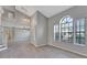 Bright living room with large windows, staircase, and gray vinyl flooring at 975 Cross Cut Way, Longwood, FL 32750