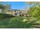 Spacious backyard with green lawn and home exterior featuring a charming tile roof at 9783 Covent Garden Dr, Orlando, FL 32827