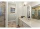 Bathroom offering tiled shower stall, vanity with marble countertop, and arched doorways at 9783 Covent Garden Dr, Orlando, FL 32827