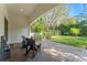 Covered brick patio has comfortable chairs and overlooks a lush, green backyard at 9783 Covent Garden Dr, Orlando, FL 32827