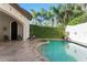 Backyard pool with an adjacent spa, complemented by lush greenery and a private patio area at 9783 Covent Garden Dr, Orlando, FL 32827