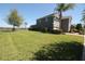 Wide view of the backyard, with a large grass area bordered by shrubs, trees and lake at 10303 Atwater Bay Dr, Winter Garden, FL 34787