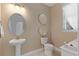 Bathroom with pedestal sink, toilet, and window providing natural light at 10303 Atwater Bay Dr, Winter Garden, FL 34787