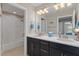 Modern bathroom with dual sinks, sleek black cabinetry, and a shower with white tiling at 10303 Atwater Bay Dr, Winter Garden, FL 34787