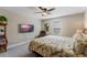 Comfortable bedroom with a floral-patterned bedspread, a ceiling fan, and a wall-mounted television at 10303 Atwater Bay Dr, Winter Garden, FL 34787