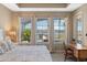 Bedroom showing tray ceiling, desk, bed, and exterior window at 10303 Atwater Bay Dr, Winter Garden, FL 34787