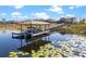Waterfront home featuring a covered boat dock with lift surrounded by a serene lake with lily pads at 10303 Atwater Bay Dr, Winter Garden, FL 34787