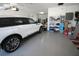 Clean garage features epoxy flooring, storage shelving, and a stylish white SUV at 10303 Atwater Bay Dr, Winter Garden, FL 34787