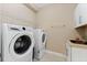Laundry room with white, front load washer and dryer, storage and sink at 10303 Atwater Bay Dr, Winter Garden, FL 34787