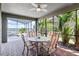 Covered patio with brick floors, a round table with four chairs, ceiling fan, and views of the pool and lake at 10303 Atwater Bay Dr, Winter Garden, FL 34787