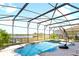 A screened pool with a built-in spa, lake views, a lounge chair, and lush landscaping at 10303 Atwater Bay Dr, Winter Garden, FL 34787