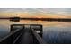 Scenic water view featuring a wooden dock with railing overlooking calm waters and a colorful sunset at 10303 Atwater Bay Dr, Winter Garden, FL 34787