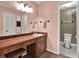 Bathroom features a wood vanity with a white sink, accented by decorative art and a commode area at 1105 Woodbine St, Fern Park, FL 32730