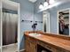Bathroom featuring a wood vanity with white sink and a view of the walk-in shower and closet at 1105 Woodbine St, Fern Park, FL 32730