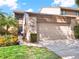 Two-story condo featuring manicured plants, landscaping, a driveway, and an attached two-car garage at 1105 Woodbine St, Fern Park, FL 32730