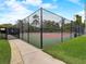 Fenced tennis court with a green and red surface, ideal for sports enthusiasts in a secure setting at 1105 Woodbine St, Fern Park, FL 32730
