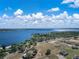 Scenic aerial view of a serene lakeside community with lush greenery and single-Gathering homes against a blue sky backdrop at 1113 Caloosa Ridge Way, Babson Park, FL 33827