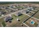 Aerial view of a residential community featuring new homes, spacious yards, and community amenities, including a pool at 1113 Caloosa Ridge Way, Babson Park, FL 33827