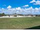 Expansive grassy backyard enclosed by a white fence, offering ample space for recreation and privacy at 1113 Caloosa Ridge Way, Babson Park, FL 33827