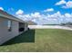 Spacious backyard features lush green grass and a white vinyl fence, offering privacy and ample space for outdoor activities at 1113 Caloosa Ridge Way, Babson Park, FL 33827