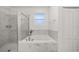Bright bathroom features separate glass shower, soaking tub with marble surround, and neutral accents at 1113 Caloosa Ridge Way, Babson Park, FL 33827