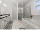 Bright bathroom features double vanities, separate glass shower, and soaking tub with marble surround and accents at 1113 Caloosa Ridge Way, Babson Park, FL 33827