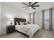 Bright bedroom featuring a ceiling fan, wood-look floors, and large windows dressed with elegant gray curtains at 1113 Caloosa Ridge Way, Babson Park, FL 33827