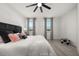 Bright bedroom featuring a ceiling fan, wood-look floors, and large windows dressed with elegant gray curtains at 1113 Caloosa Ridge Way, Babson Park, FL 33827