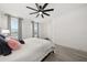 Spacious bedroom featuring a ceiling fan, wood-look floors, and large windows dressed with elegant gray curtains at 1113 Caloosa Ridge Way, Babson Park, FL 33827