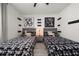 Shared bedroom featuring twin beds with unique black and white patterned bedding and modern art accents at 1113 Caloosa Ridge Way, Babson Park, FL 33827