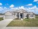 Charming single-story home featuring stone accents, a well-manicured lawn, and a two-car garage at 1113 Caloosa Ridge Way, Babson Park, FL 33827