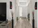 Bright hallway showcasing light wood floors, decorative accents, and a welcoming front door at 1113 Caloosa Ridge Way, Babson Park, FL 33827