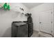 Clean laundry room equipped with modern, dark-colored washer and dryer units and a white door at 1113 Caloosa Ridge Way, Babson Park, FL 33827
