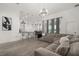 Open-concept living room featuring a modern chandelier, large windows, and a spacious sectional sofa at 1113 Caloosa Ridge Way, Babson Park, FL 33827