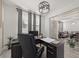 Bright office featuring a modern chandelier, desk, and large windows dressed with elegant gray curtains at 1113 Caloosa Ridge Way, Babson Park, FL 33827