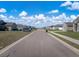 Quiet suburban street view featuring well-kept homes, sidewalks, and parked cars on a sunny day at 1113 Caloosa Ridge Way, Babson Park, FL 33827