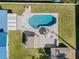 Aerial view of backyard features a pool with patio furniture and an outdoor shed surrounded by a well-maintained lawn at 1189 Lazy Hollow Pl, Winter Park, FL 32792