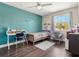 Cozy bedroom featuring sleek wood floors, an accent wall, and bright natural light from a side window at 1189 Lazy Hollow Pl, Winter Park, FL 32792