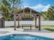 Wooden gazebo with picnic table positioned beside a crystal-clear in-ground swimming pool at 1189 Lazy Hollow Pl, Winter Park, FL 32792