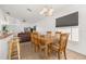 Open-concept dining area with a wooden table, bar stool seating, tile flooring and an adjacent living area at 121 Sonja Cir, Davenport, FL 33897