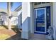 Close-up of a home's bright blue front door with sidelights, a charming welcome mat, and a decorative lawn ornament at 121 Sonja Cir, Davenport, FL 33897