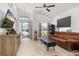 Bright living room with wood-look floors, a ceiling fan, vaulted ceilings, and large windows providing ample natural light at 121 Sonja Cir, Davenport, FL 33897